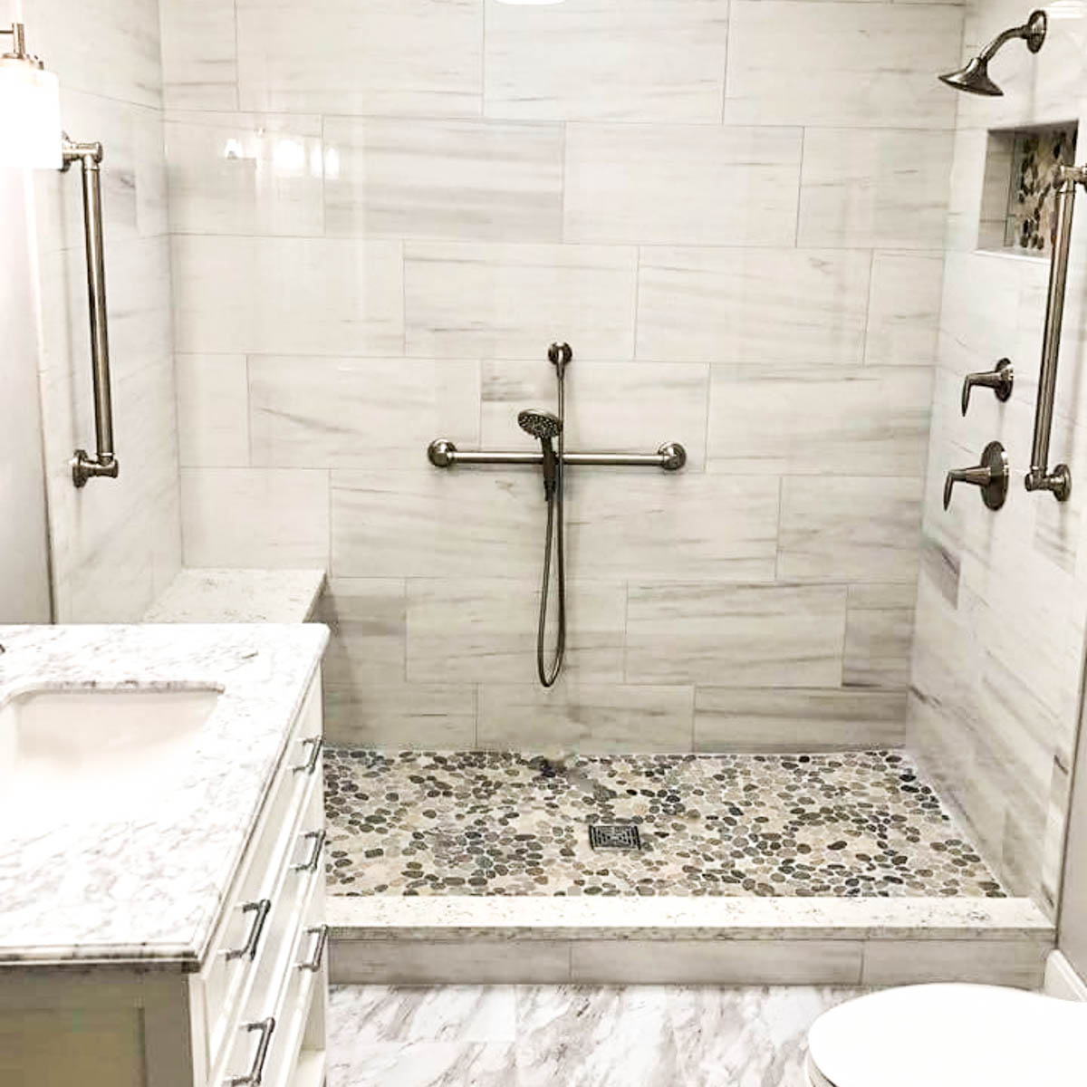 Gray and white shower with bronze hardware