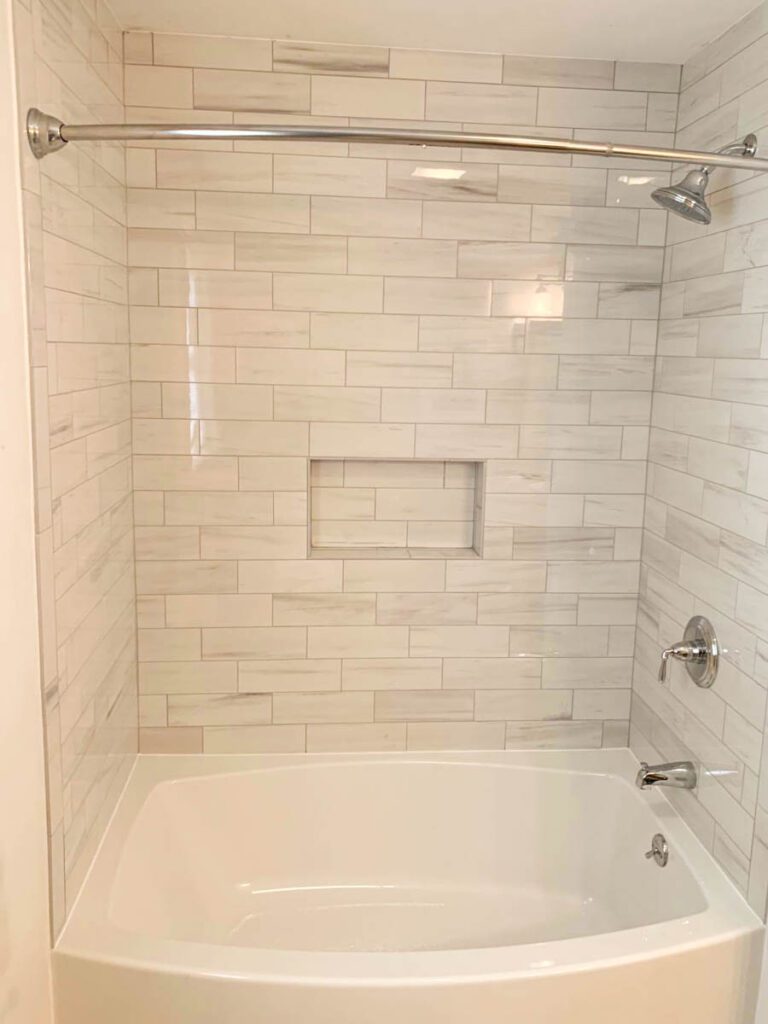 Gray and white subway tiled tub and shower