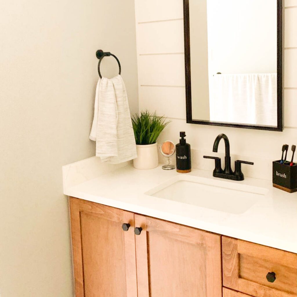 Wood vanity with white counter and walls