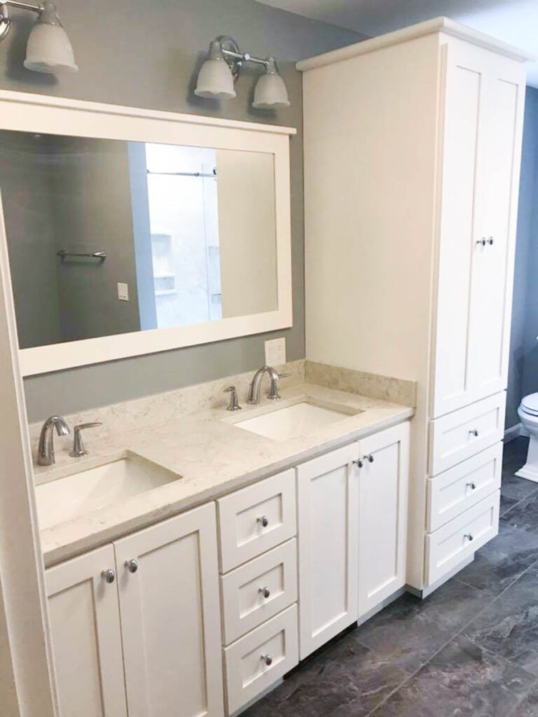 White bathroom vanity with floor to ceiling cabinet storage