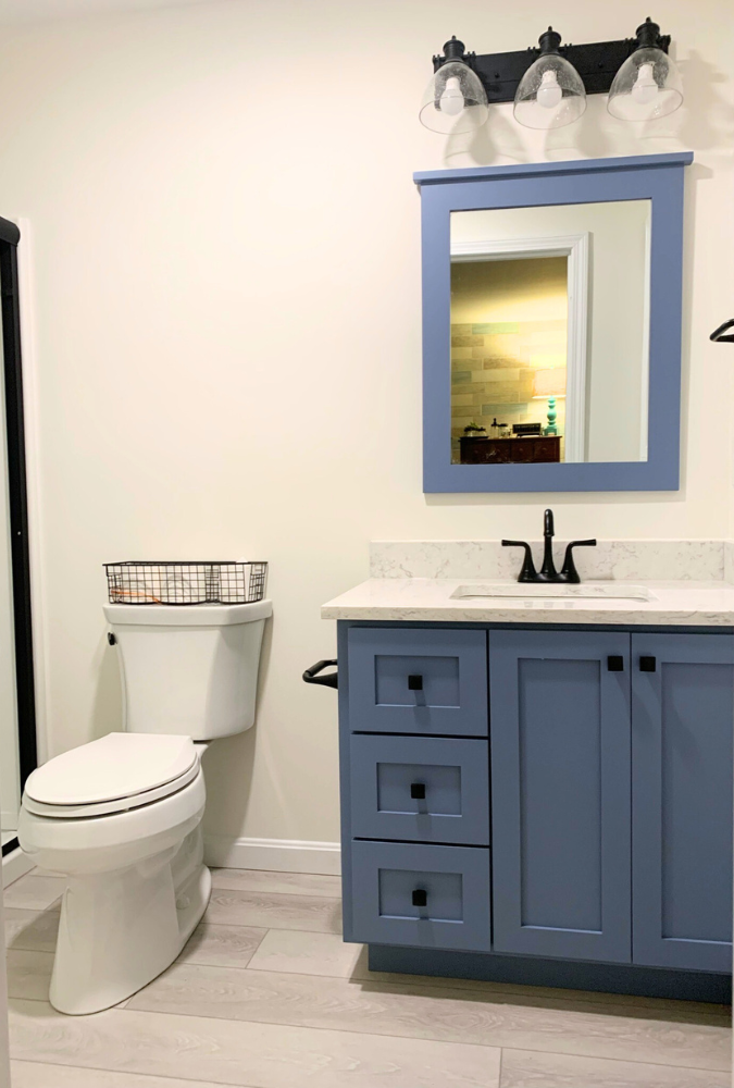 Bathroom with blue vanity and mirror